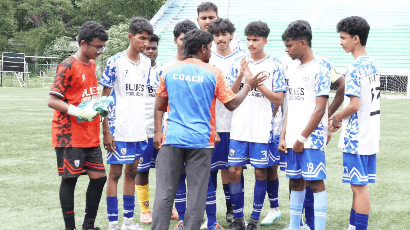 Coach giving feedback to players at the end of a session